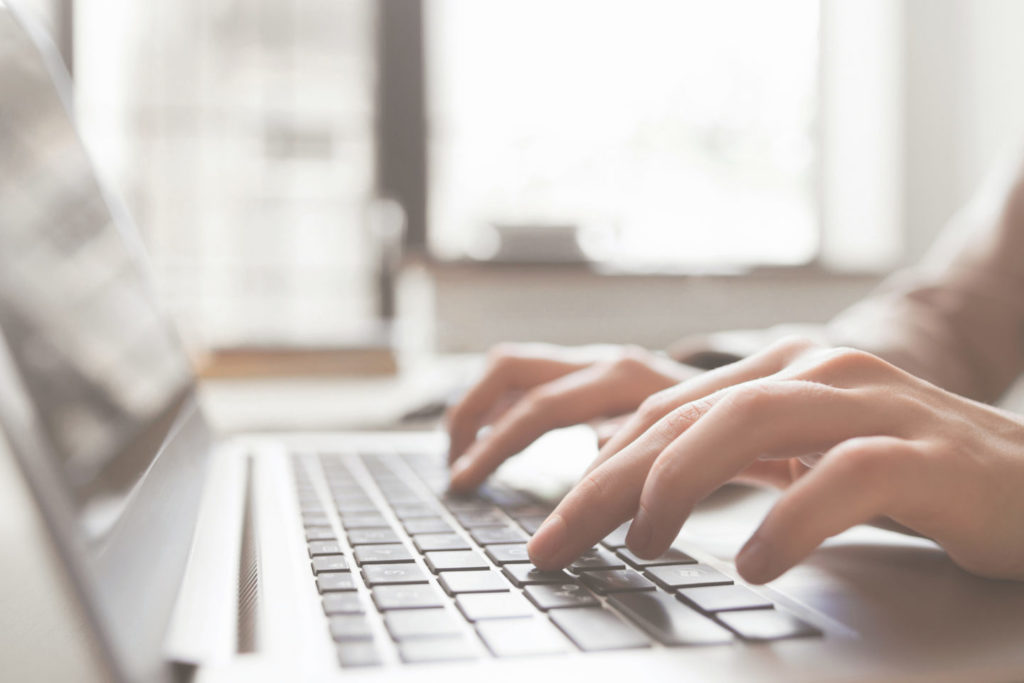 Fingers on laptop keyboard